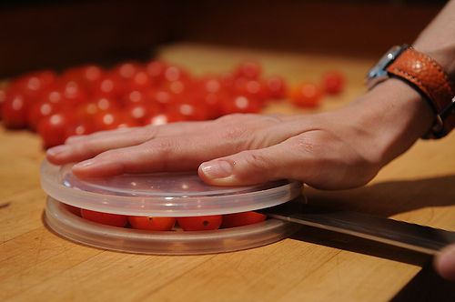 Slicing cherry tomatoes (or grapes) in half easily